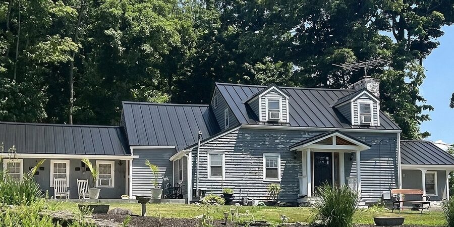 Same house with a new black metal roof (AI preview)